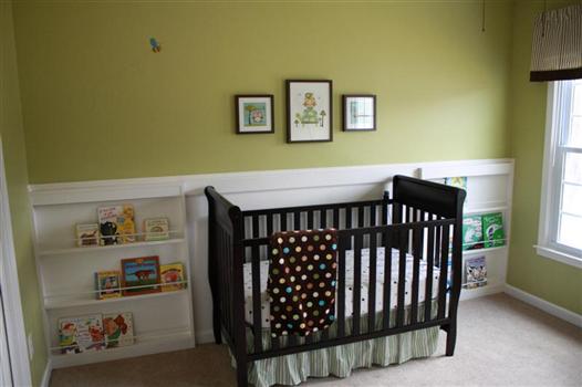 green baby boy nursery with dark wood crib