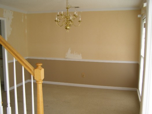 Dining room: brass hardware, old torn wallpaper, beige walls, tan carpet