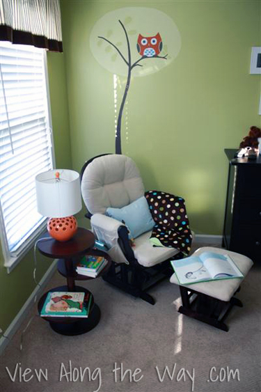 Green boy nursery with owl mural and orange lamp