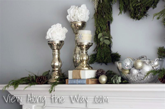 Silver Candlesticks with white candles and snowballs on a Christmas Mantle Silver Candlesticks with white candles and snowballs on a Christmas Mantle