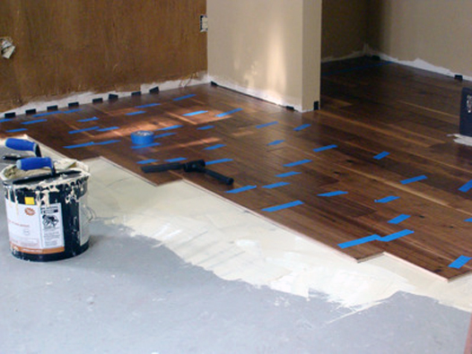 Floor adhesive being added to the hardwood floor.