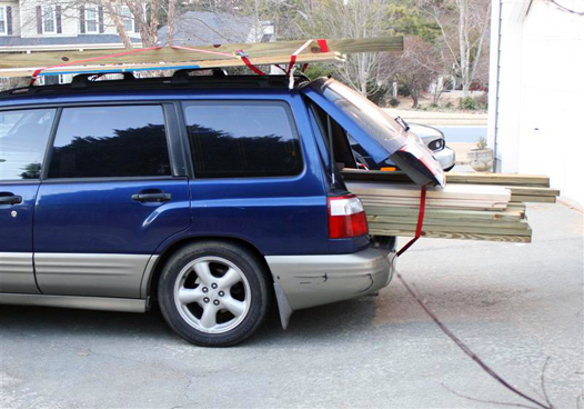 Blue subaru forrester suv full of lumber