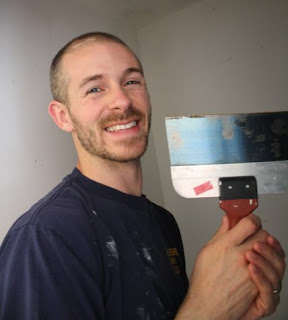 Using a putty knife to scrape popcorn ceilings