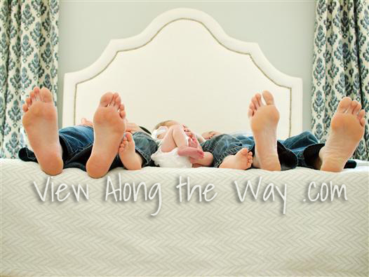 Family feet on upholstered bed