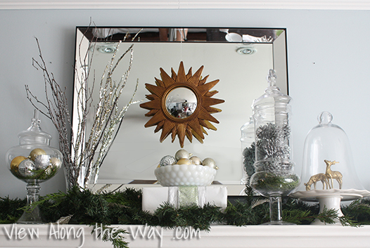 Mirrored Christmas mantel with sunburst mirror and greenery
