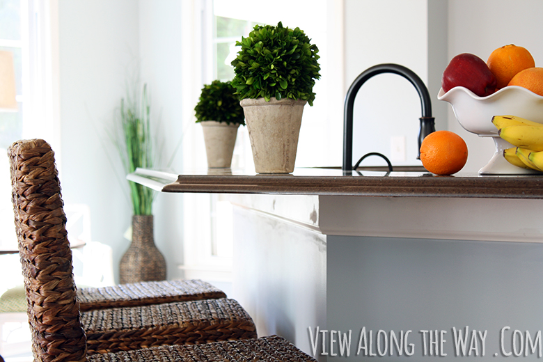 Kitchen bar with preserved boxwood potted balls and wicker barstools (Click through for more preserved boxwood inspiration!)