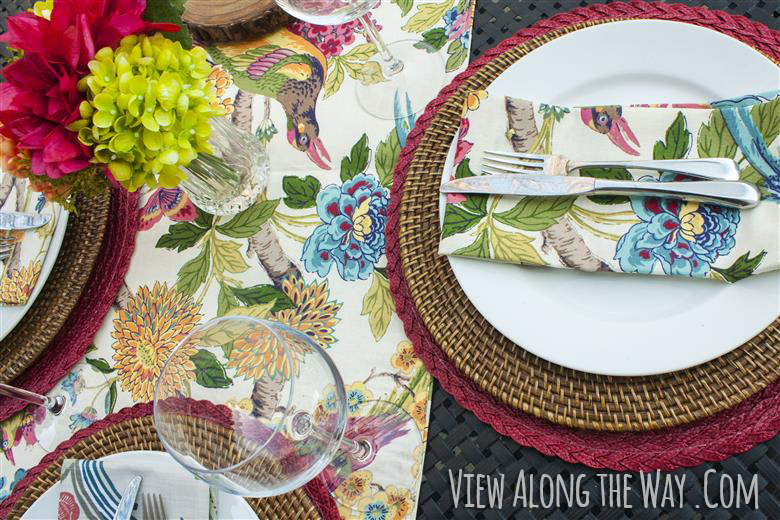 Place setting with multicolored runner and flowers on an outdoor table at View Along the Way