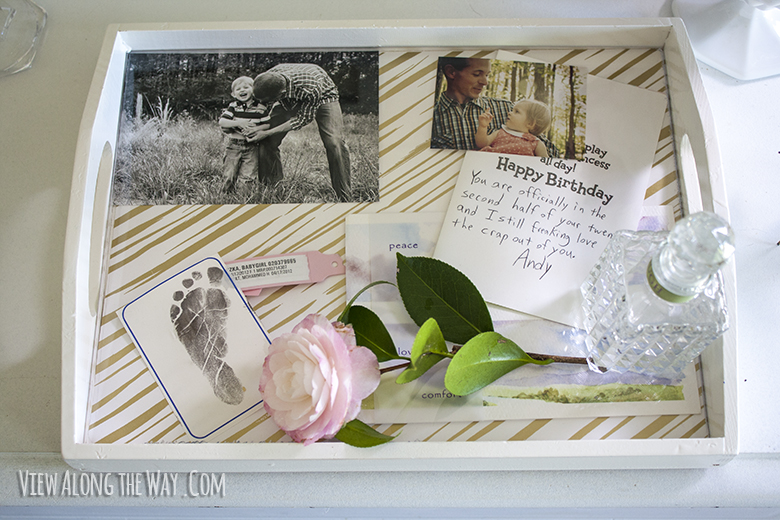Tray lined with photos and mementos under a sheet of acrylic. Great way to bring memories into your decor in a classy way!