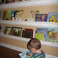 Make front-facing bookshelves out of a rain gutter - plus other creative front-facing bookshelf and DIY wall decor ideas!