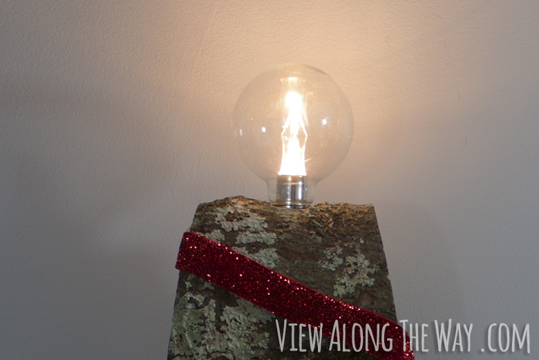 Lightbulb on top of a DIY advent tree made of firewood!