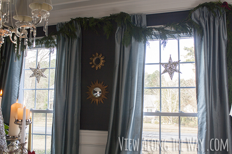 Windows decorated for Christmas with shimmery stars and live rope garland