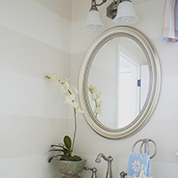 Updated bathroom with mirrored vanity and striped walls