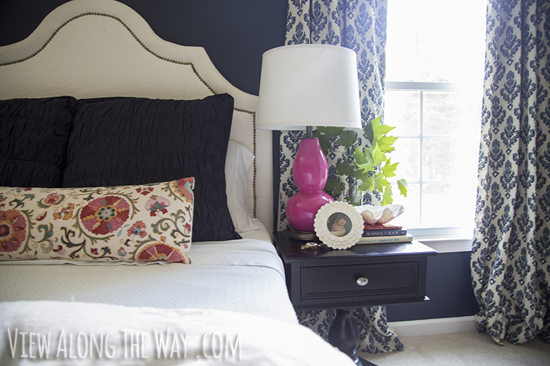 Navy bedroom with pink lamp